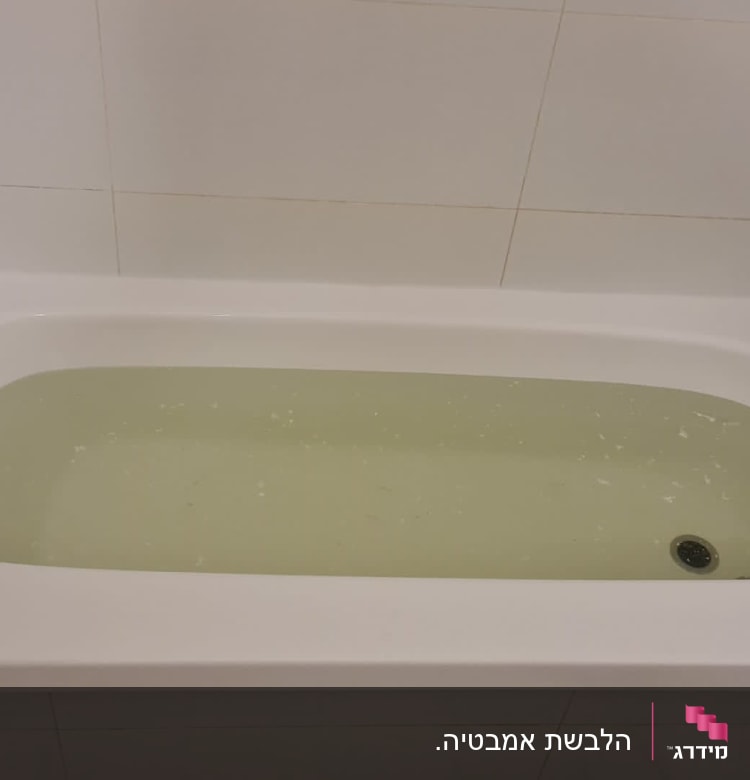 אמבטיה עם מים צהבהבים וברז מתכת